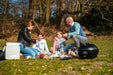 Cadac Citi Chef 40 Black - Urban & Camping Gas BBQ lifestyle image of family have picnic with BBq in front, food on blanket and two kids, two adults
